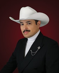 a man in a white cowboy hat with a mustache